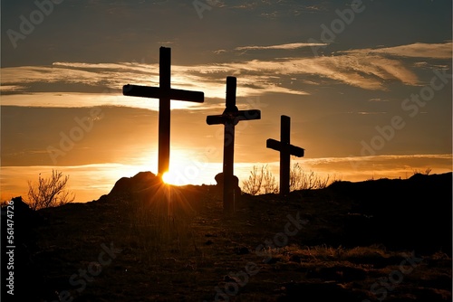 Fotografia Three crosses stand on a barren, windswept terrain, silhouetted against a darkening sky, as the sun sets behind them