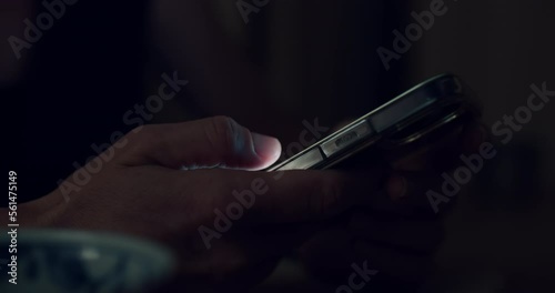 Side view of woman use smartphone, screen lit fingers swipe and scroll through content on the screen. Push buttons, follow links. Nighttime phone using