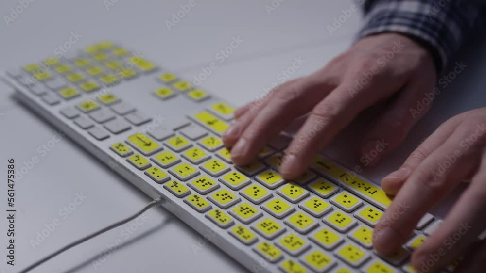 Close-up: A man uses a keyboard with braille.A blind man is typing words on the buttons with her hands. Technological device for visually impaired people. Tactilely touches bumps on the keys Close-up: A man uses a keyboard with braille.A blind man is typing words on the buttons with her hands. Technological device for visually impaired people. Tactilely touches bumps on the keys