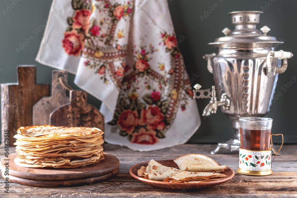 Pancakes for Maslenitsa. A stack of Russian thin pancakes. Samovar and tea on the table.Traditional Russian festive food. Country style.