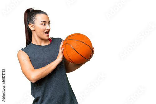 Young beauty woman over isolated chroma key background playing basketball © luismolinero