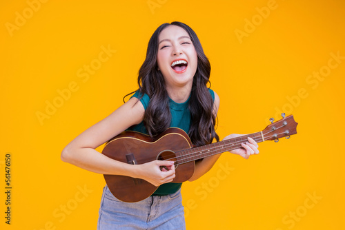 ready to party cheerful asian female woman signing joy fun toothy smile big laugh wearing casual cloth freshness action pose pretending perform in concert studio shot on yellow background