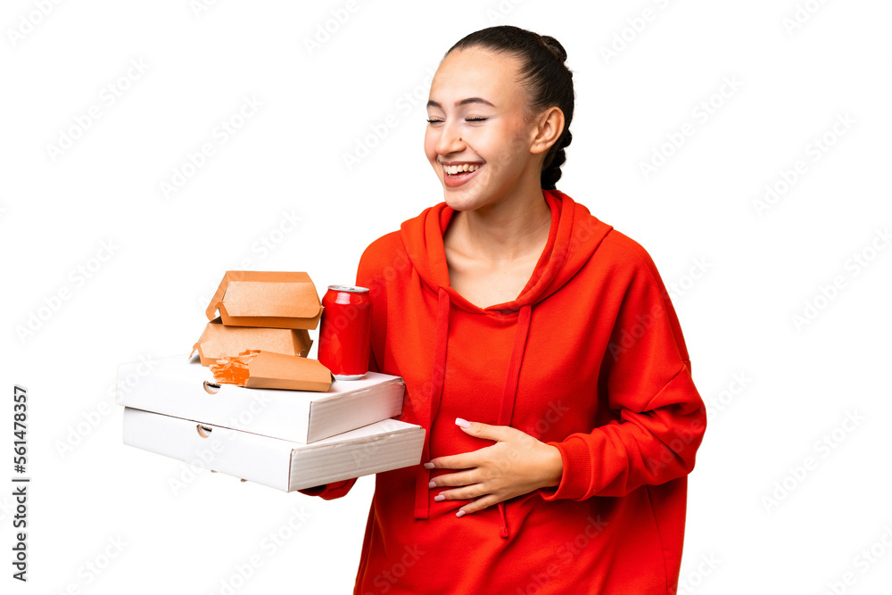 Young Arab woman holding fast food over isolated background smiling a lot Young Arab woman holding fast food over isolated background smiling a lot