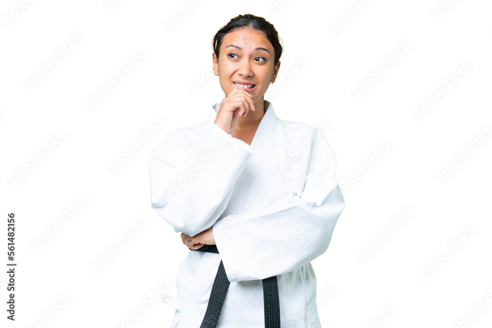 Young Uruguayan woman doing karate over isolated chroma key background having doubts and thinking Young Uruguayan woman doing karate over isolated chroma key background having doubts and thinking