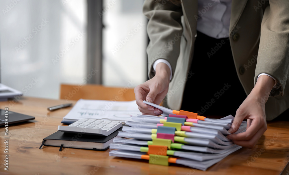 Business Documents concept, woman hands working on Stacks paper files for checking document achieves on folders papers at office. Business Documents concept, woman hands working on Stacks paper files for checking document achieves on folders papers at office.