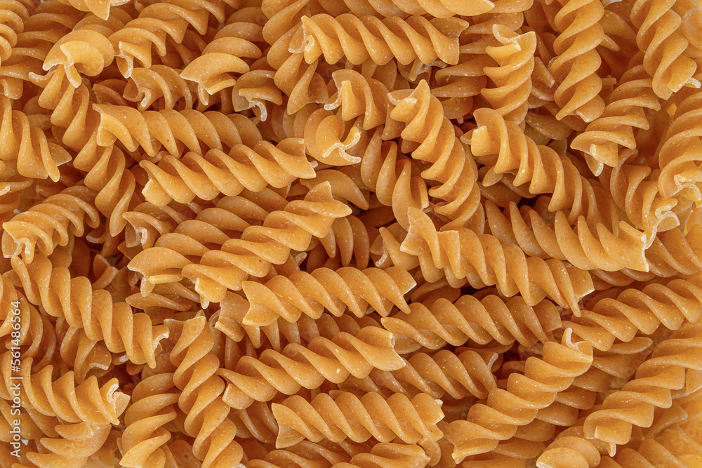 Italian whole wheat organic pasta fusilli background. Top view, close up. Italian whole wheat organic pasta fusilli background. Top view, close up.