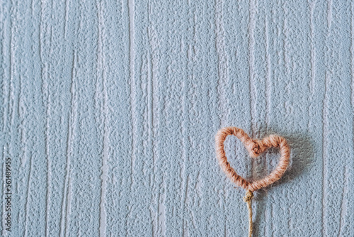 Coeur rose en laine sur un fond vide tapisserie rétro