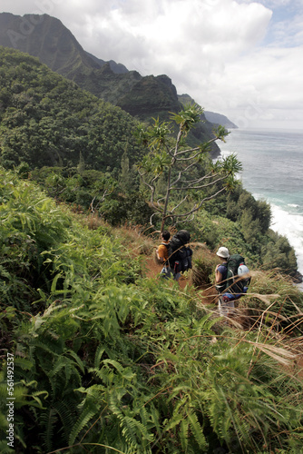 A young couple hike the Kalalau trail on Kauai, Hawaii. photo