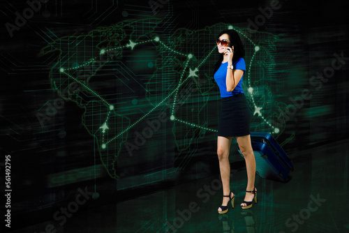 Woman talking on the phone pulling a suitcase on futuristic map background © Creativa Images