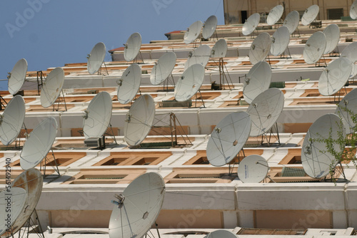 Satellite dishes on the side of an apartment block photo