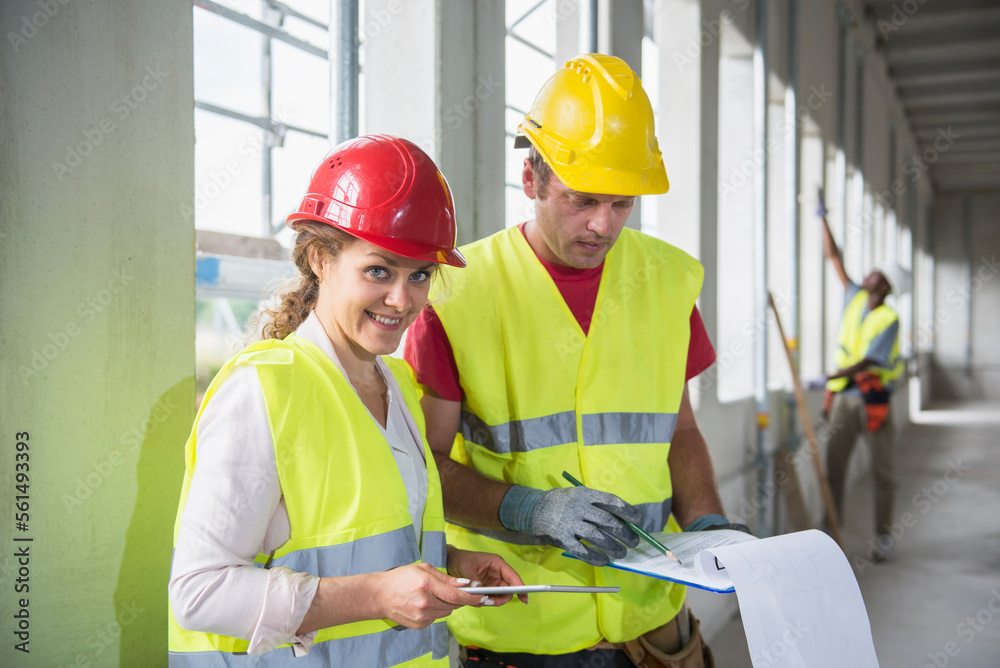 Construction workers with digital tablet and document at building site Construction workers with digital tablet and document at building site