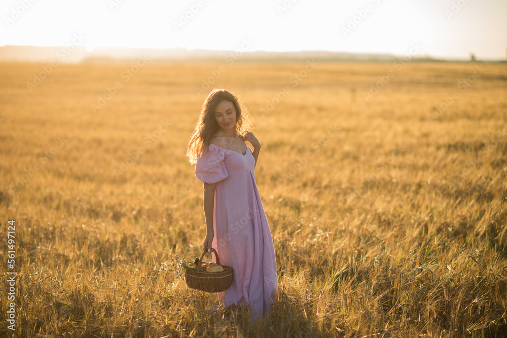 a happy girl with dark long hair walks in a wheat field at sunset, the concept of happiness and unity with nature