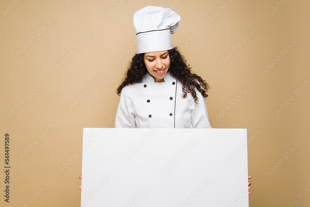 Woman chef showing the menu after cooking Woman chef showing the menu after cooking