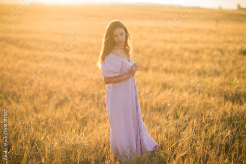 portrait of a happy young girl in a dress in a wheat field at sunset, the concept of peace and unity with nature