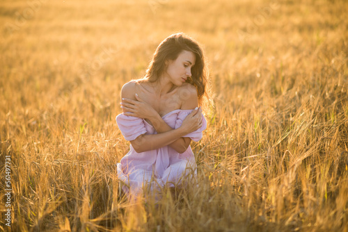 portrait of a happy young girl in a dress in a wheat field at sunset, the concept of peace and unity with nature