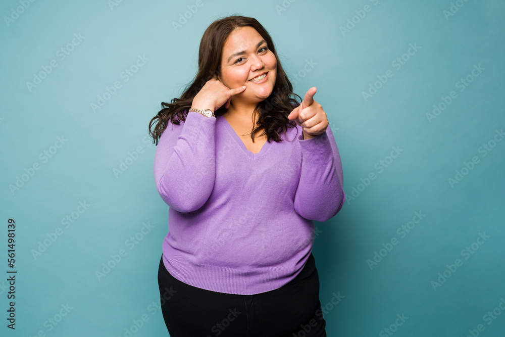 Cheerful big woman asking for a call or talk on the phone Cheerful big woman asking for a call or talk on the phone