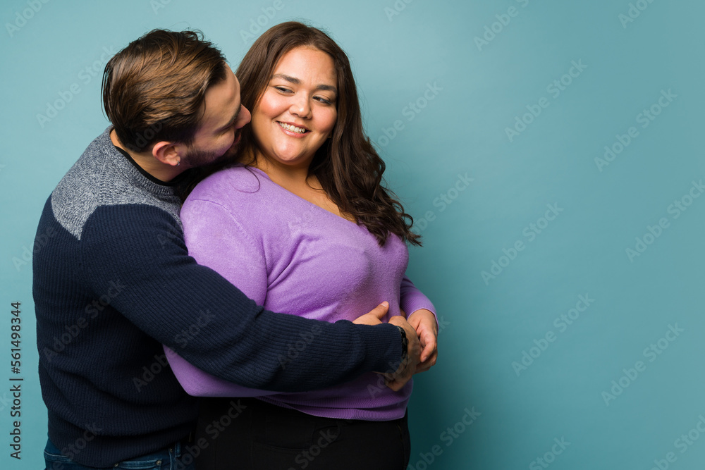 Adorable man kissing and hugging her big girlfriend Stock-Foto | Adobe Stock