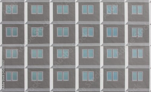 Minimalist facade of modern office building with square Windows. Frontal view of the facade of building with a lot of windows with people staying at home during quarantine.