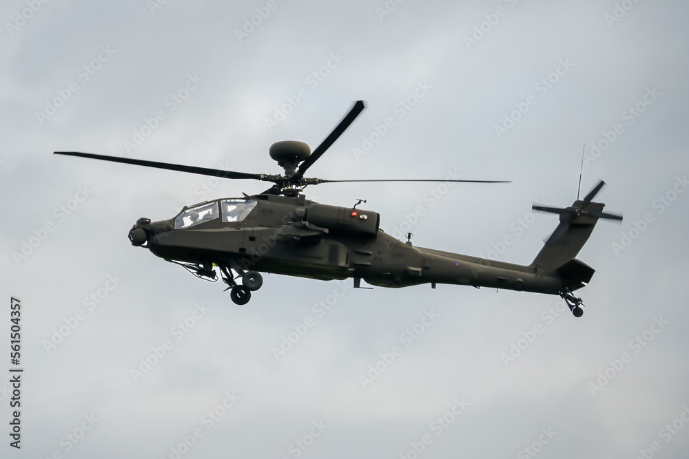 a dark coloured helicopter flying low to the ground a dark coloured helicopter flying low to the ground