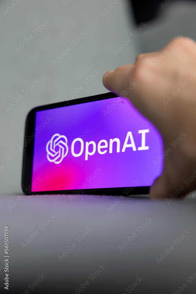 Woman's hand holding an iPhone with OpenAI logo. ChatGPT and ...