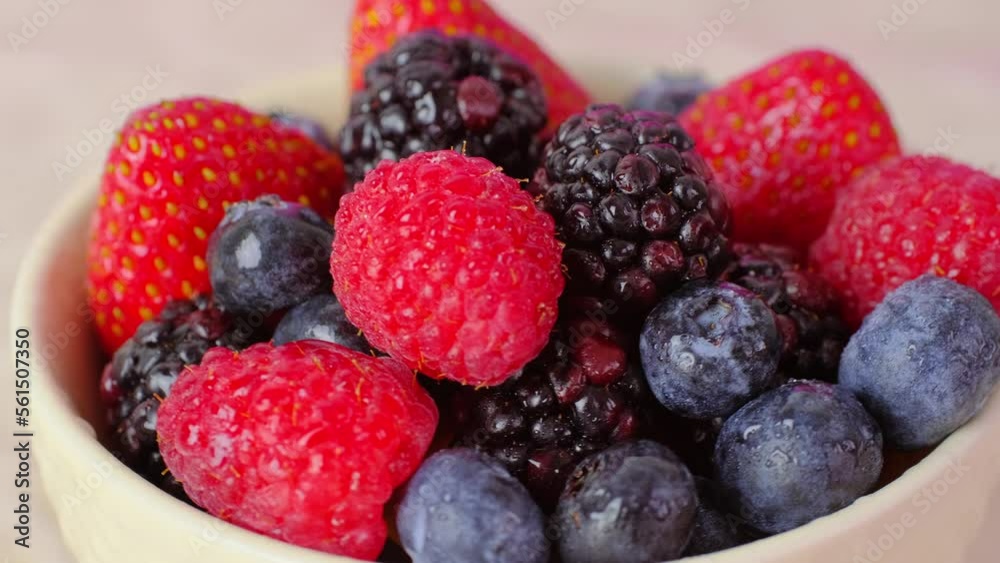 Various berries in a bowl, fresh strawberry, blueberry and raspberry, close up video of mix or red and blue berries, slow motion rotation. High quality 4k footage Various berries in a bowl, fresh strawberry, blueberry and raspberry, close up video of mix or red and blue berries, slow motion rotation. High quality 4k footage