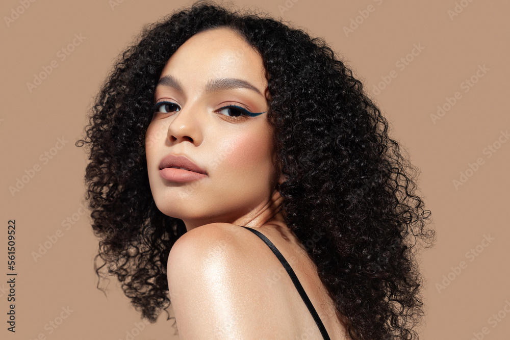 © Mirrorstudio - Beautiful young woman on beige background. Natural makeup, glowing dark skin © Mirrorstudio - Beautiful young woman on beige background. Natural makeup, glowing dark skin