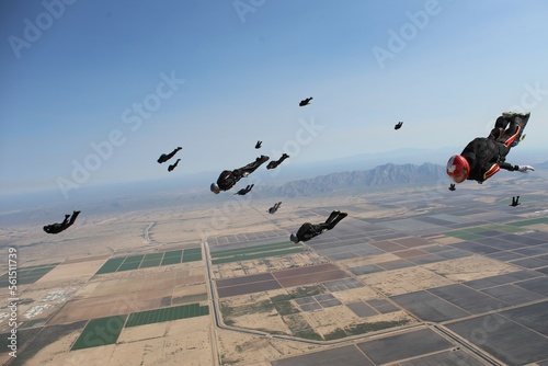 Skydivers tracking from a skydive in Arizona with mountain range in the background. photo