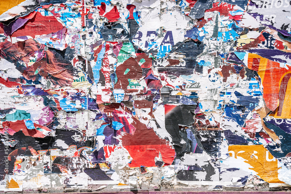 Naklejka premium Torn paper collage background on an old poster on a street wall. Texture and surface of torn paper.