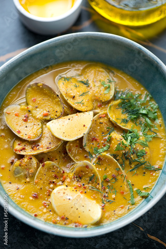 Close-up of chickpea cream-soup with littleneck clams, vertical shot, selective focus photo