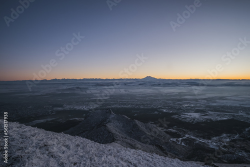 Panorama from Mount Beshtau to the city, a winter landscape in the evening at sunset, a panorama with icy and snow-covered trees on the mountainside