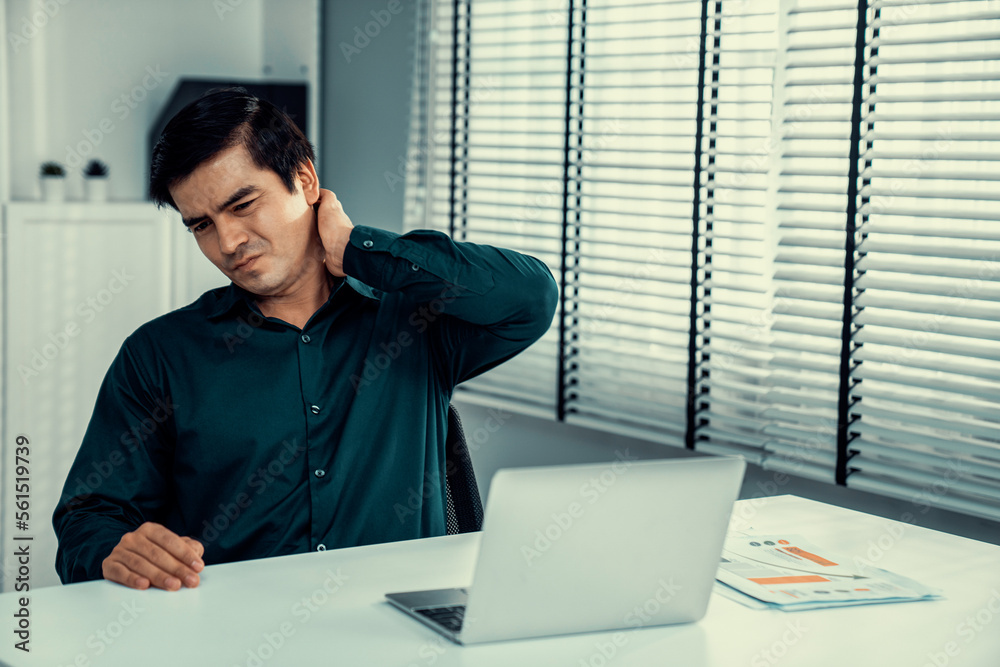 Competent asian office worker experiencing fatigue and neck pain ...