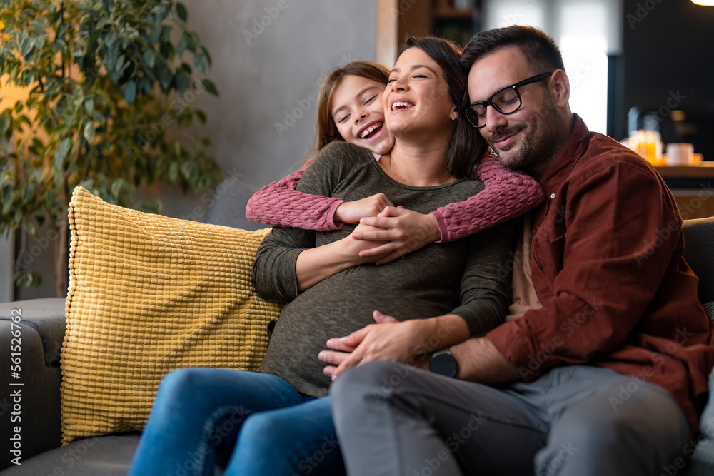Photo of a little girl with her pregnant mother and caring father having a relaxing cheerful moment at home. Photo of a little girl with her pregnant mother and caring father having a relaxing cheerful moment at home.