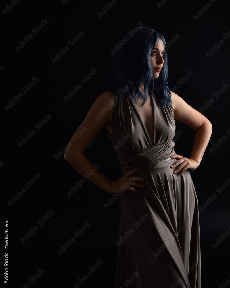 close up portrait of pretty girl with blue hair wig & elegant gown with expressive facial expressions & gestural arm poses. colourful neon gel lighting, isolated on studio background. close up portrait of pretty girl with blue hair wig & elegant gown with expressive facial expressions & gestural arm poses. colourful neon gel lighting, isolated on studio background.