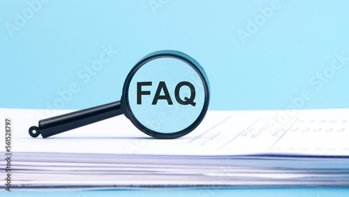 magnifying glass with FAQ - frequently asked question, inscription on a blue background.