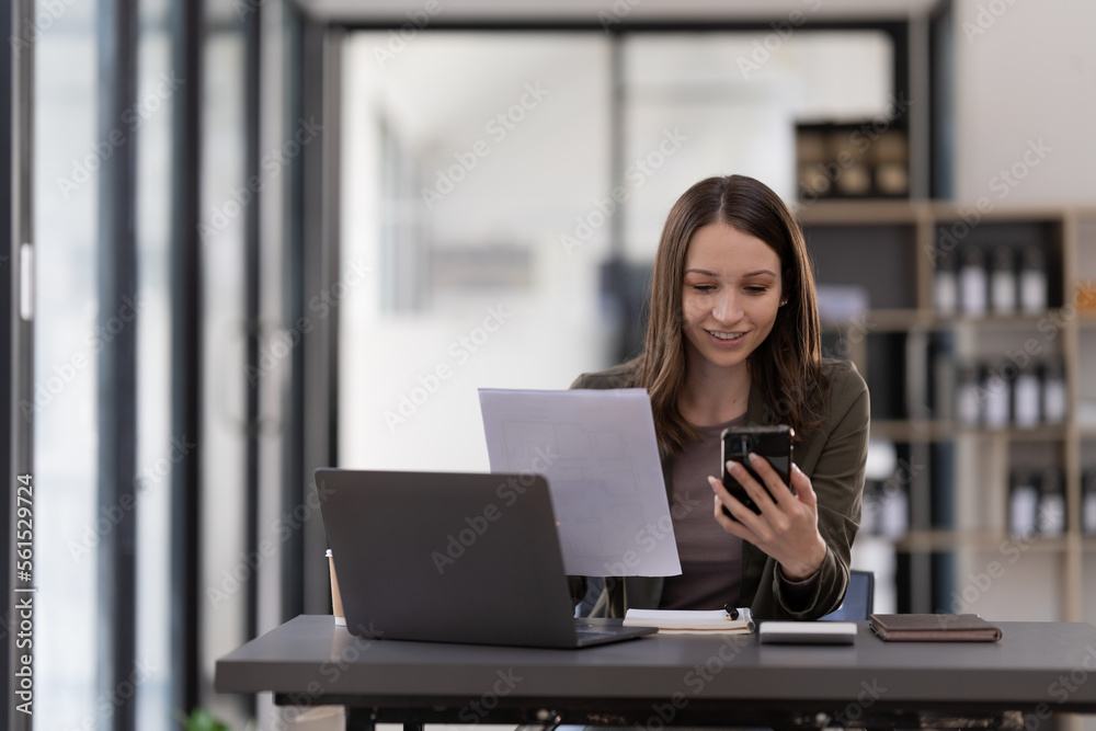Business woman using smartphone for do math finance on wooden desk in office, tax, accounting, financial concept. Business woman using smartphone for do math finance on wooden desk in office, tax, accounting, financial concept.