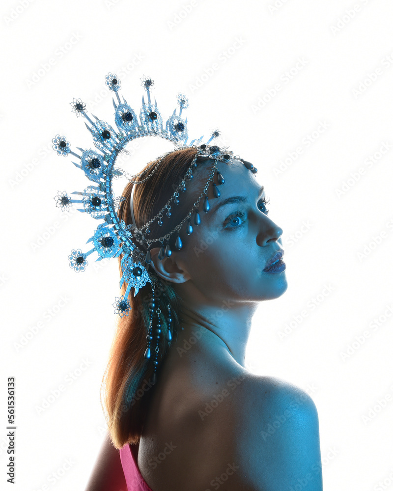 Φωτογραφία Close up portrait of beautiful girl in side profile, wearing an ornate silver crown headpiece, glowing silhouette lighting on white studio background