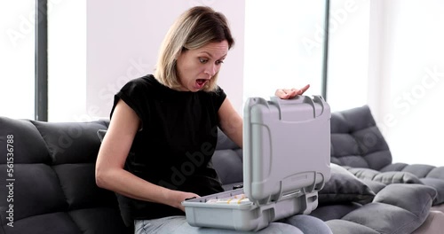 Joyful happy woman looks into asuitcase with money photo