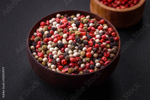 Allspice peas in a wooden bowl on a black concrete background