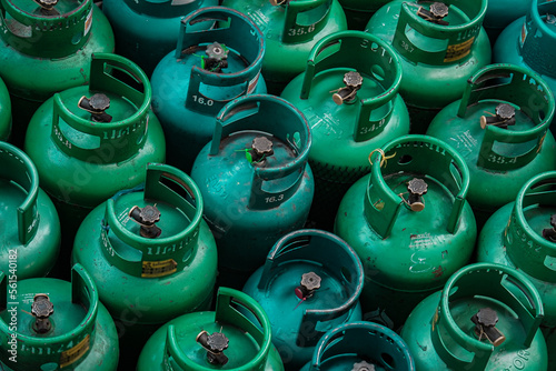 LPG gas green  bottle stack ready for sell, stand in pattern.  Thai language stamp on the bottle said 