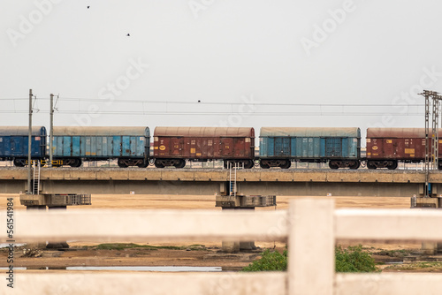 Wagons of an Indian Railways goods train crossing a bridge.