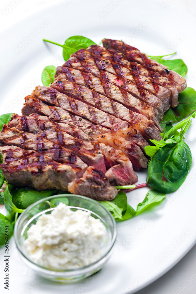 beef steak with garlic dip and spinach and ruccola leaves