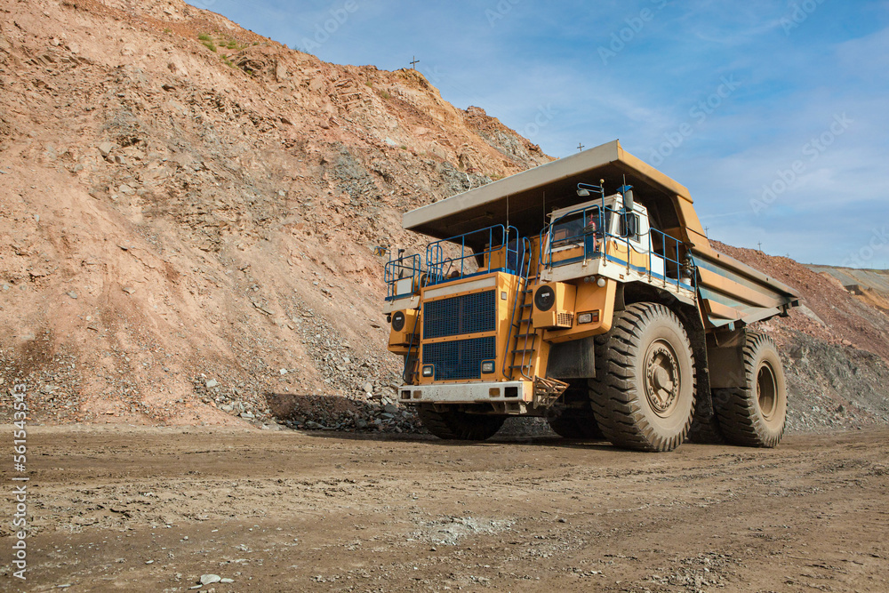 Large dump truck for removal of rock mass from the quarry for open-pit mining of minerals. Initial stage of melalurgy, machinery for the extraction of raw ore.
