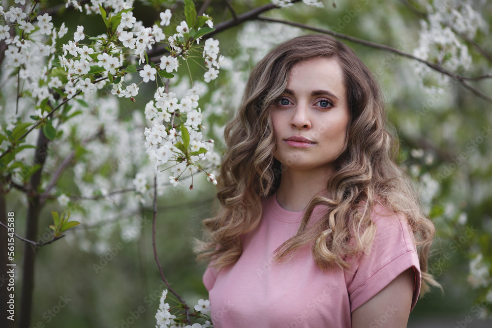 Portrait beautiful fashion model woman in spring. Flowers blossoms. Blooming in garden Portrait beautiful fashion model woman in spring. Flowers blossoms. Blooming in garden