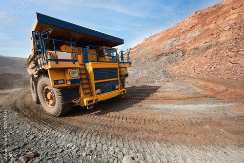 Large dump truck for removal of rock mass from the quarry for open-pit mining of minerals. Initial stage of melalurgy, machinery for the extraction of raw ore.