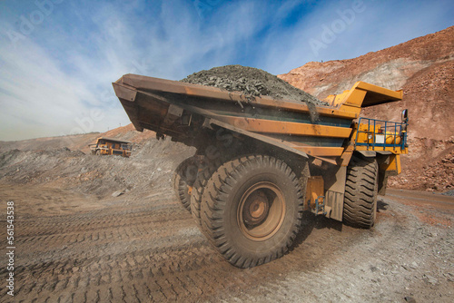 Large dump truck for removal of rock mass from the quarry for open-pit mining of minerals. Initial stage of melalurgy, machinery for the extraction of raw ore.