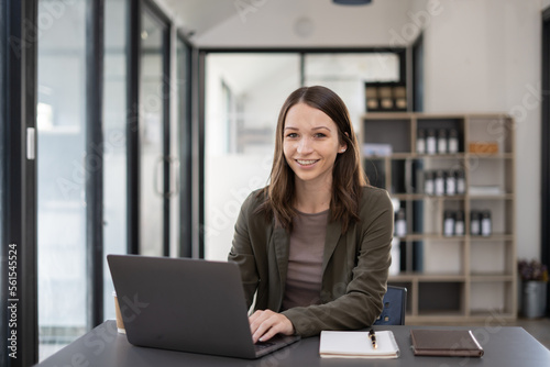 Beautiful woman at the modern office with a computer laptop.