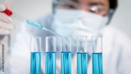 Asian woman Scientist experimental in laboratory with test tube and beaker for medical research