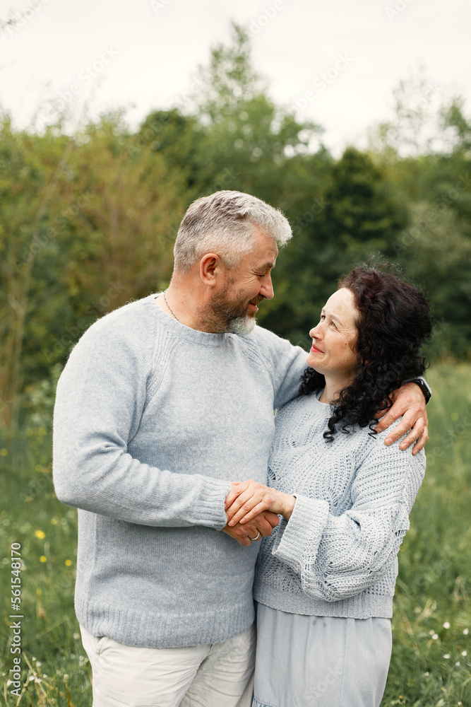 Senior couple standing in a park and looking on each other Senior couple standing in a park and looking on each other