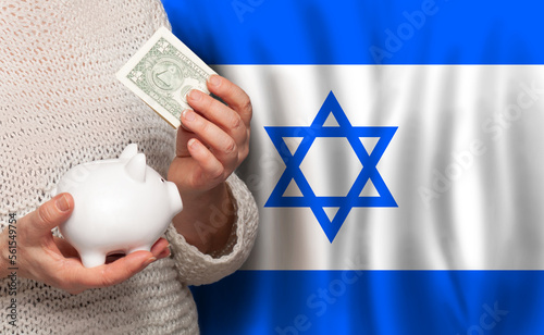 Izraeli woman with money bank on the background of Izrael flag. Dotations, pension fund, poverty, wealth, retirement concept