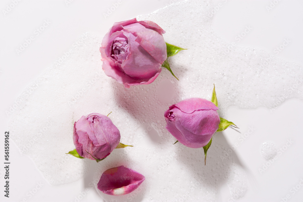 Roses foam water closeup. Rosebuds float in soapy water. The concept